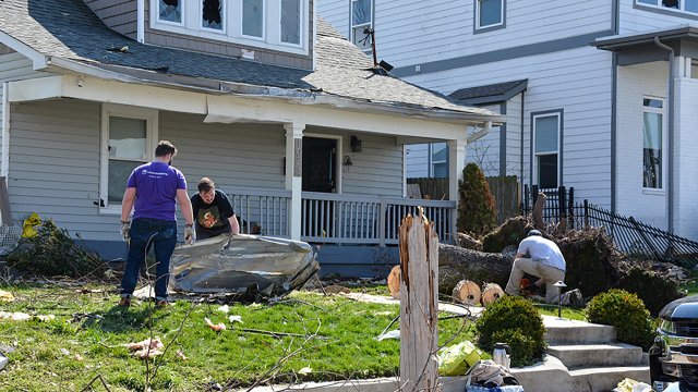 Nashville, Tennessee, 2020: People clean trash from their yard and start to cut a fallen tree the morning after a tornado rips through Nashville.